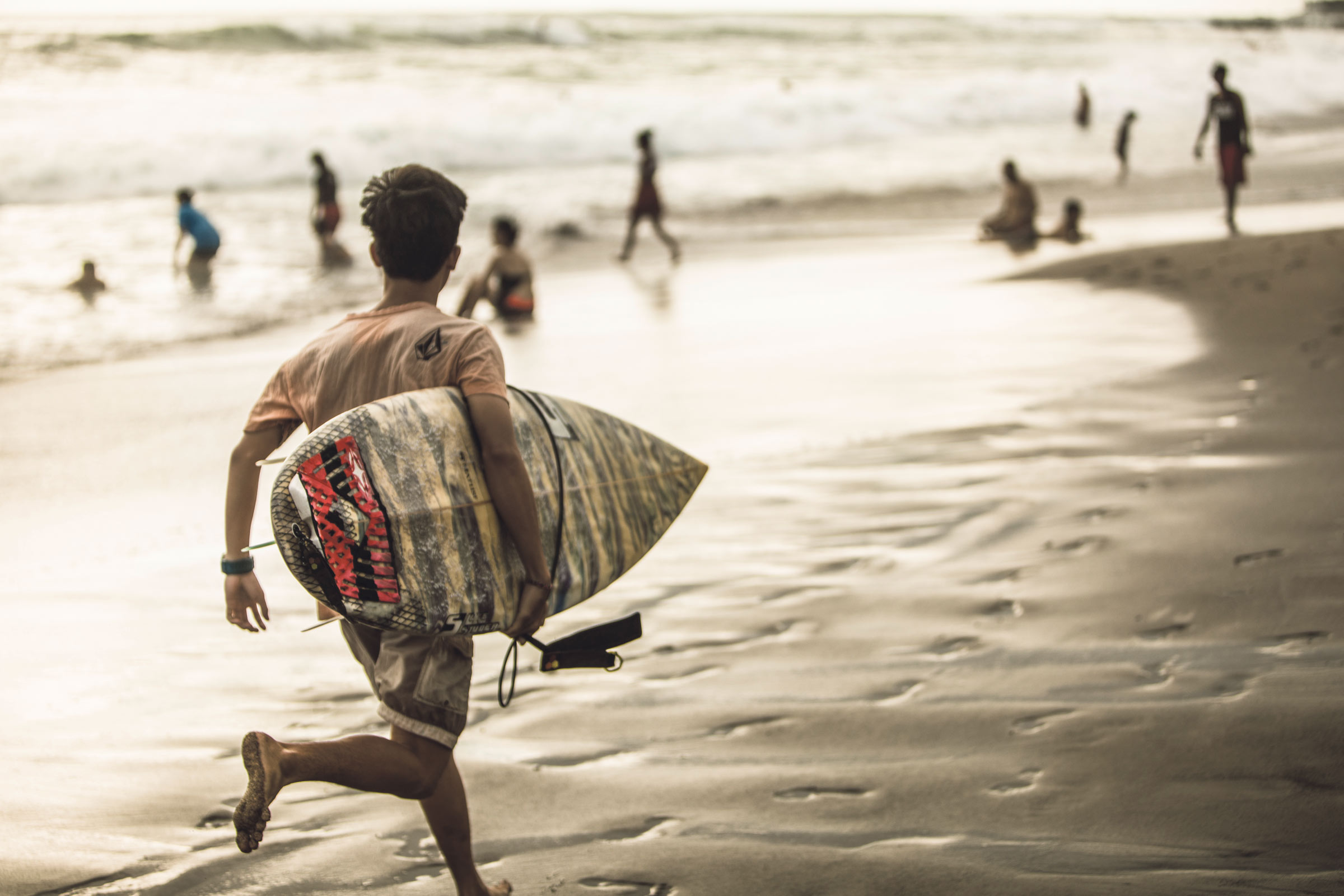 Kind mit Surfbrett am Strand