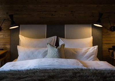 Doppelbett vor Holzwand